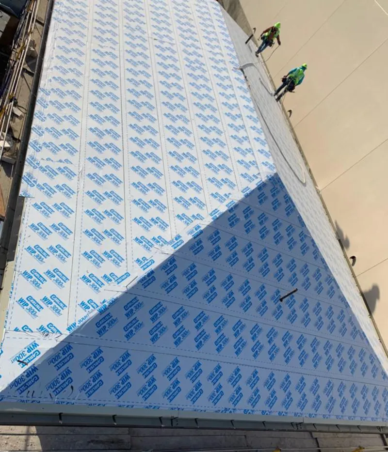 Professional roofers installing underlayment on a metal roof in Peru